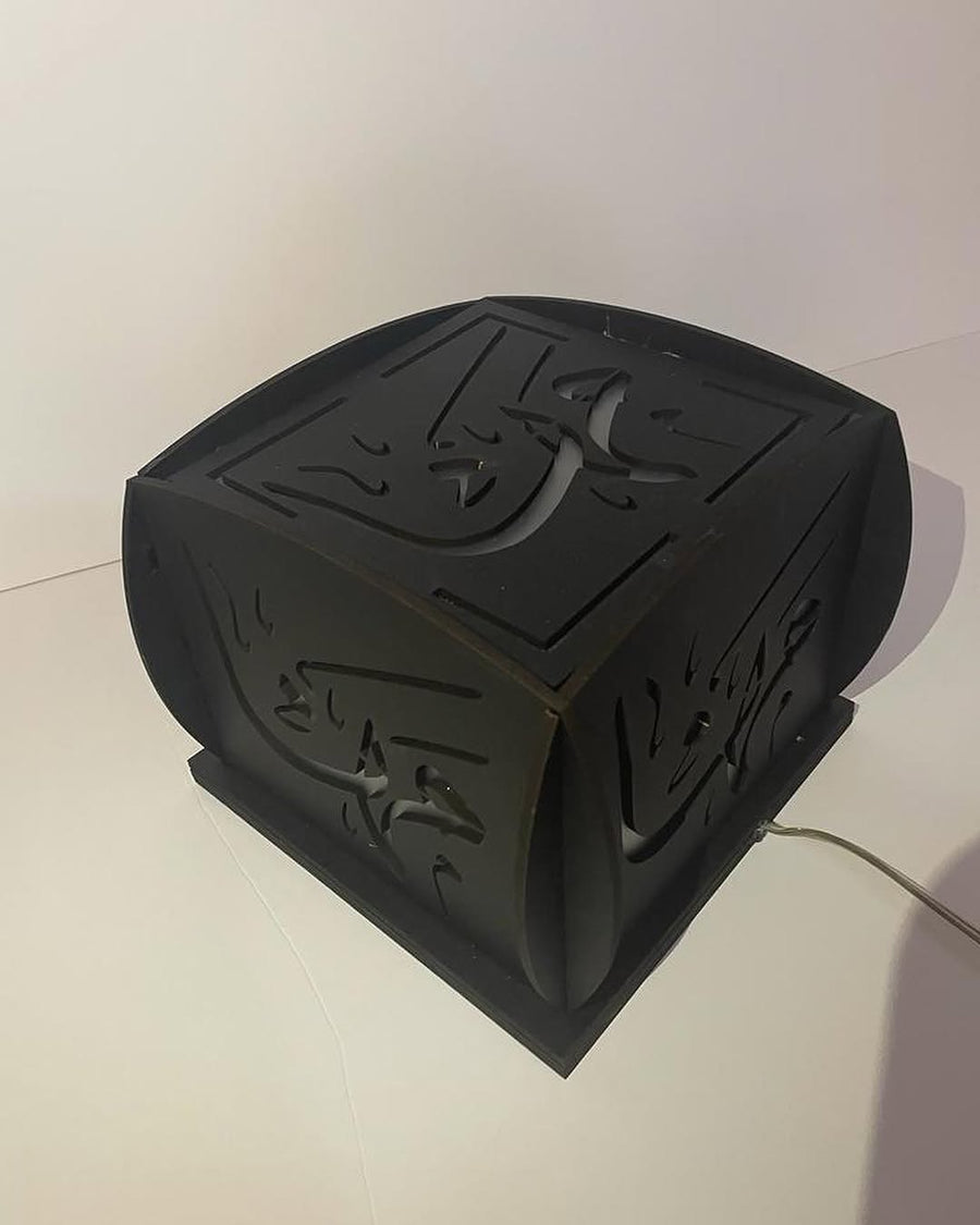 A Light box rendered in hand-cut Arabic calligraphy, backlit as a custom lamp.